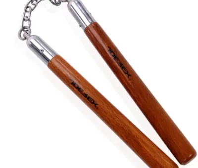 Les nunchakus sont généralement mis en vente dans des boutiques spécialisées en article de sport ou arts martiaux. Un nunchaku en métal convient parfaitement à ceux qui veulent se perfectionner. Ce type d’arme est composé de deux branches en métal ou en acier inoxydable qui peuvent être reliées à l’aide d’une chaîne ou d’une corde. Dans cet article, nous allons voir ensemble les étapes à accomplir pour attacher une chaine à un nunchaku en métal. Comment faire pour fixer une chaine sur un nunchaku en métal ? Pour réussir cette opération, vous allez avoir besoin de six boulons, huit rondelles et deux vis. Une fois le matériel prêt, vous devrez procéder comme suit : 1. D’abord, fait un trou à environ 1cm du haut de chaque branche du nunchaku. Mais, il faudra avant marquer l’endroit où vous allez percer. 2. Pour fixer la chaîne, nous allons avoir besoin de deux vis, six boulons et huit rondelles. 3. Après avoir pointé les deux branches, servez-vous d’une petite mèche (diamètre de 2 à 3 millimètres) pour faire un pré-trou. Ce dernier permet de guider la mèche de plus gros diamètre. Ensuite, il faudra percer par-dessus avec une mèche de 8 millimètres. 4. Maintenant, fixez la vis, les rondelles, les boulons et la chaine, sur chaque branche du Nunchaku. Assurez-vous qu’ils soient correctement maintenus. 5. Si la taille de la vis n’est pas adaptée, choisissez une autre plus grande et coupez-la en utilisant une pince coupante ou une scie. 6. Laissez-la vis tourne sur elle-même pour qu’elle ne provoque pas de dommage sur le nunchaku au moment des rotations. 7. Voilà, votre arme est prête à utiliser, il ne vous reste qu’à vérifier un petit détail : le poids ! Comment identifier le poids approprié à votre nunchaku ? Si vous maitrisez déjà l’utilisation du Nunchaku, vous pourrez donc identifier le poids adéquat pour pouvoir s’entrainer et créer des enchainements avec cette arme. Pour cela, faites quelques mouvements pour voir si votre outil vous semble trop lourd ou bien trop léger. S’il est lourd, vous ne pourrez rien faire malheureusement. Vous devrez simplement choisir une matière moins lourde (par exemple l’aluminium). Dans le second cas, vous devrez l’alourdir en ajoutant quelques grammes qui pourraient faire une différence. L’idéal est de rajouter progressivement quelques grammes sur chaque branche. Pour cela, vous pouvez vous servir des bouchons de bouteille que vous découperiez en couteau, afin qu’ils rentrent facilement dans le tube. Sachez qu’un bouchon coupé pèse environ 5 grammes qui change complètement la manipulation de cet outil. Si vous désirez rajouter plus de poids, insérez donc des plombes sur les côtés des bouchons avant de les mettre dans les branches. Il est conseillé de vous servir d’une balance qui vous permettra de vérifier et d’ajouter le même poids sur chaque bâton du Nunchaku ! Une fois le poids idéal trouvé, il vous reste un dernier point à faire, mais ce n’est pas obligatoire. En général, les nunchakus en métal peuvent abimer les mains lors de l’entrainement, ce qui peut être gênant pour certaines personnes. Afin d’y remédier, utilisez une petite pince pour tordre le haut des tubes de façon à ce qu’ils ne provoqueront pas de pincements. Maintenant, vous pourrez vous entrainer en toute sécurité ! Autre méthode pour relier les deux branches de Nunchaku Il existe une autre technique pour attacher les deux branches de Nunchaku avec une chaine. Pour cela, vous devrez vous munir d’une corde de petit diamètre, d’une chaine et de deux branches déjà percées. En effet, vous devrez faire 4 trou au niveau du haut des branches. Assurez-vous que le diamètre est largement suffisant pour faciliter le passage de la corde au minimum 4 fois. Ensuite, vous devrez faire passer la corde 5 à 7 fois, soit en effectuant un nœud avec les deux extrémités de la corde ou soit en les laissant à l’intérieur des branches. Cela dépend du nombre de passages que vous avez fait. Enfin, vous devrez répéter la même chose sur la deuxième branche de votre Nunchaku !
